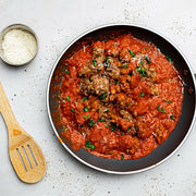 Rock House Creamery Sweet Italian Sausage - 1 lb. - Ground, featuring premium Berkshire pork with housemade spices, alongside a wooden spatula and shredded cheese in a bowl.