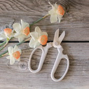 The Floral Society | Japanese Floral Clippers, Citrine, shown beside daffodils on wood, highlight precision and ergonomic design, perfect for trimming and gardening tasks.