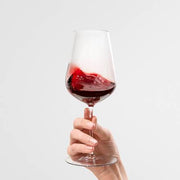 Hand holding a swirling red wine in a stemmed glass, representing Uncorked & Untamed: The Loire Valley's Natural Wine Revolution class at Athens Cooks.