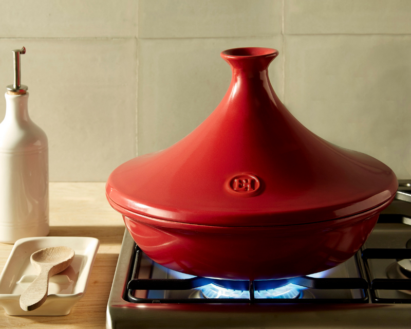Emile Henry Tart Dish on gas burner with oil cruet and spoon, showcasing durable ceramic design for even heating and easy tart release.