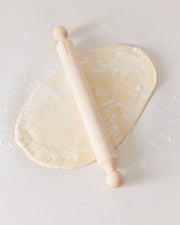 Farmhouse Pottery walnut rolling pin in use on a floured surface