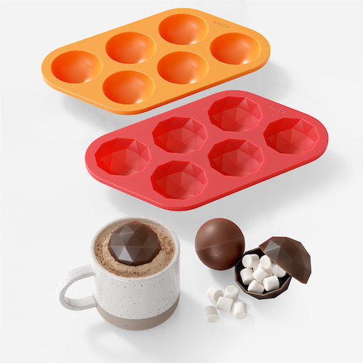 Zoku | Bomb Chocolate Mold set with smooth and faceted silicone trays, showcasing crafted chocolate bombs and a melting hot-chocolate bomb in cocoa.