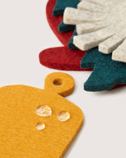Graf Lantz - Merino Wool Coaster Multi 4 Pack - Deck the Halls, featuring mustard-yellow and other vibrant felt trivets with water-repellent properties, enhancing sustainability and elegance.