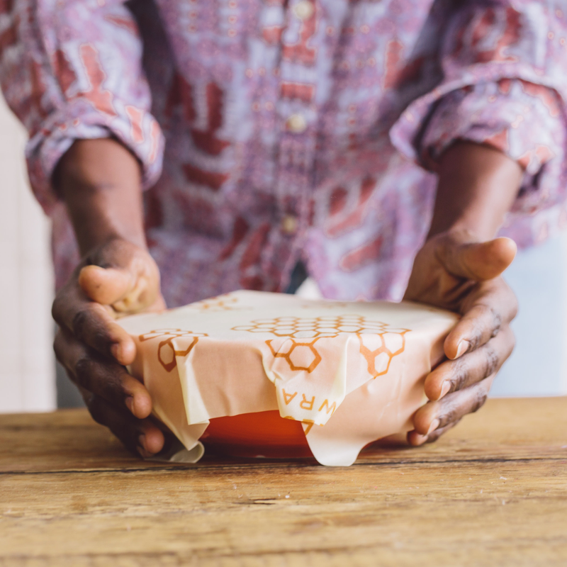Bee's Wrap - Assorted 5 Pack - Honeycomb held by a person, showcasing reusable wraps for kitchen storage, ideal for preserving food like leftovers and produce.