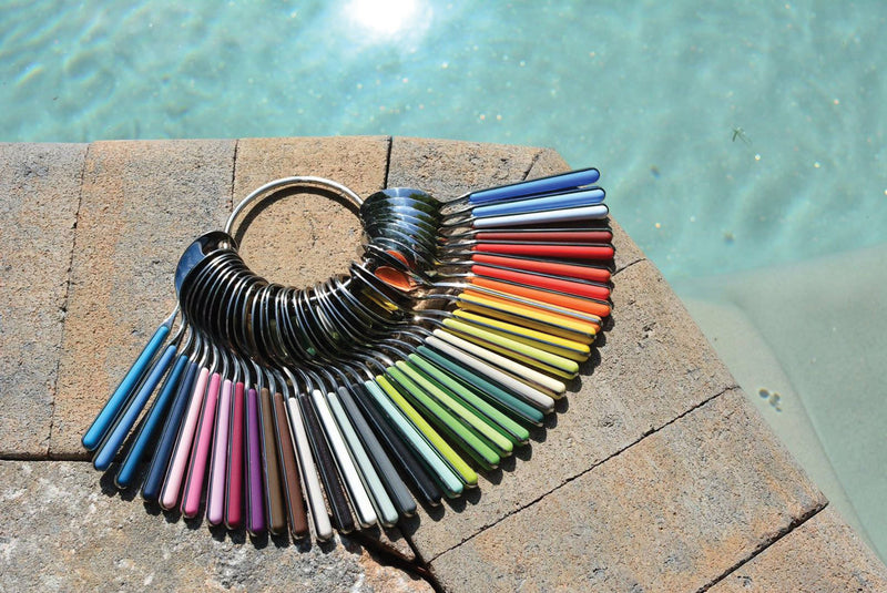 Mepra SPA - 20 PCS SET FANTASIA SAGE, featuring stainless steel spoons and forks on a stone surface, showcasing elegant Italian craftsmanship and durable materials.