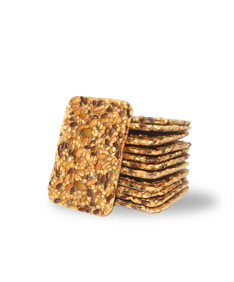 Top Seedz Sea Salt Crackers, stacked with visible seeds, offering a crunchy texture. Packaged in a 5oz box, ideal for various gourmet pairings.