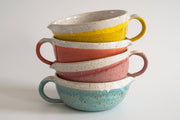 RachaelPots - Salad Dressing Bowl: Coral, featuring a stack of colorful ceramic bowls with a garlic scraper, handle, and pour spout, ideal for dressings.