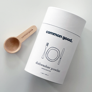 Common Good - Dishwasher Powder in a white container with a wooden spoon, designed for effective cleaning without harsh chemicals. Available for pre-order at Athens Cooks.