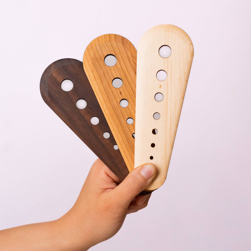 Collin Garrity - Herb Stripper: Cherry, shown in different wood tones, with graduated holes for stripping herbs and scraping seeds; available in cherry, walnut, and limited-edition maple.