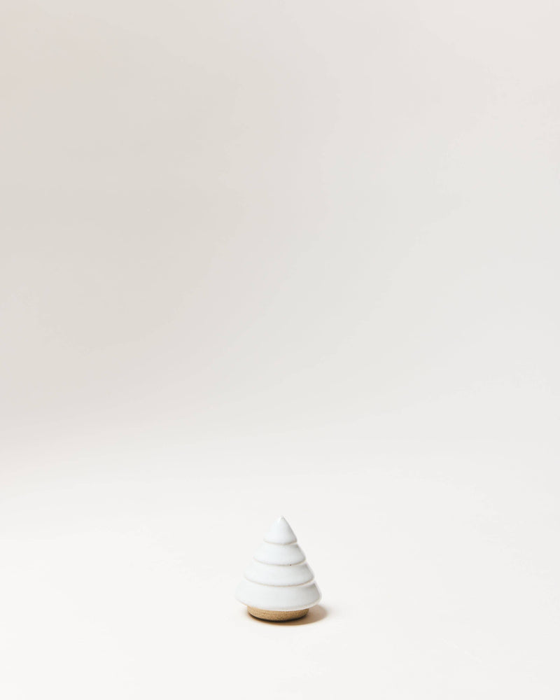 Farmhouse Pottery - Balsam Woodland Trees: Wee, a white, stepped conical stoneware piece on a light-wood base, ideal for year-round minimalist decor.