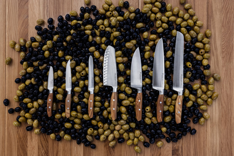 Wüsthof | Amici 8 Chef's Knife displayed atop a pile of olives, showcasing its precision and craftsmanship, available at Athens Cooks kitchen store.