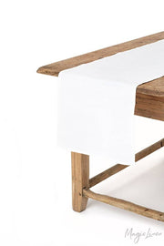 MagicLinen - Linen table runner on a wooden table, showcasing its soft texture and protective function, ideal for enhancing dining aesthetics.