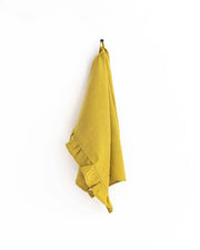 MagicLinen - Ruffle trim tea towel hanging on a hook, showcasing its soft, absorbent linen texture, perfect for stylish and practical kitchen use.