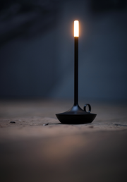 VANMOKUM | GRAYPANTS Wick Portable Rechargeable Lamp - Black, resembling a lit candle on a stand, perfect for creating ambiance in various settings.