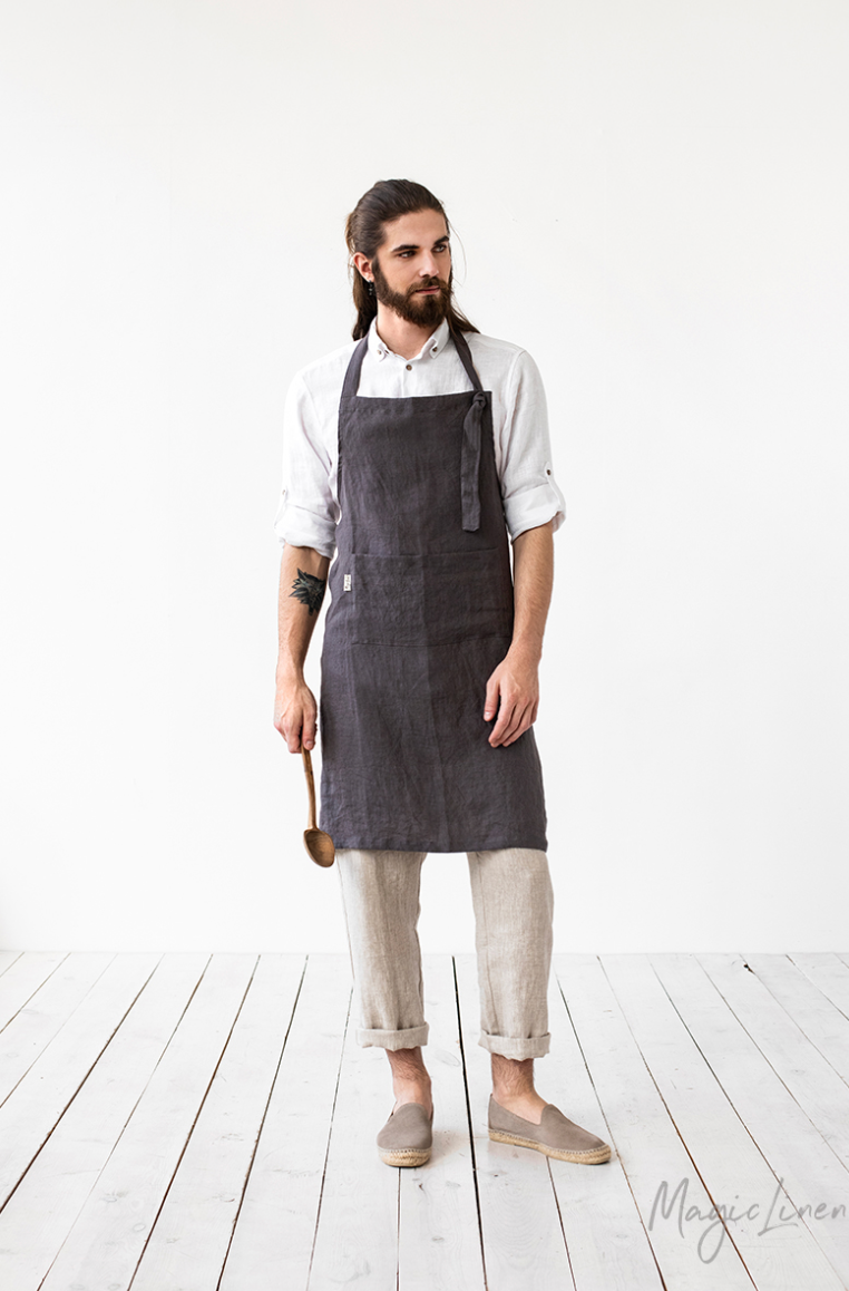 Man wearing MagicLinen men's linen apron with pocket, showcasing adjustable grommet and twin-sectioned pocket, ideal for cooking and gardening.