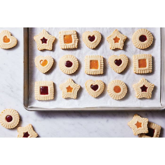 HIC - Harold Import Co. - King Arthur Thumbprint Cookie Cutters 4-Piece Set creating assorted jam-filled cookies on a baking sheet with embossed edges and center indents.