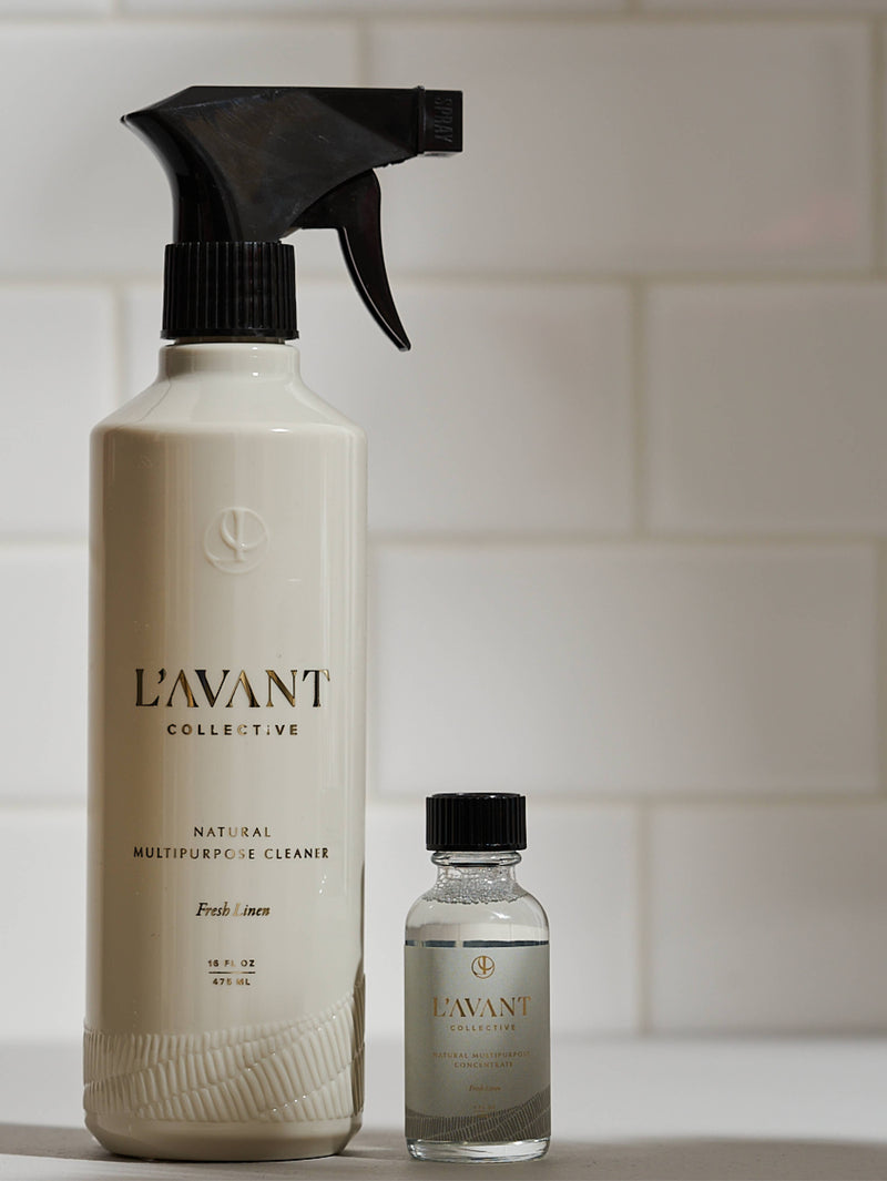 L'AVANT Collective - Fresh Linen Multipurpose Cleaner Refill in eco-luxe glass bottles, shown alongside a spray bottle, ideal for sustainable cleaning refills.