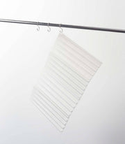 Yamazaki Home - Tower Folding Dish Drainer Mat hangs on a metal rod, showing its compact, foldable design ideal for organized kitchen spaces.