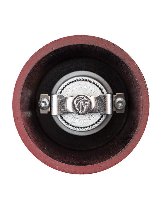 Peugeot | Bali Cast Iron Pepper Mill, Red, featuring a top-down view of its inner grinding mechanism, showcasing the Peugeot France stamped adjustment knob.