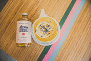 Pink House Alchemy - Lavender Simple Syrup beside a lavender soup bowl, highlighting aromatic ingredients like cane sugar and lavender flowers.