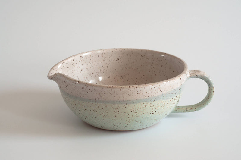RachaelPots - Salad Dressing Bowl: Coral, a hand-thrown speckled stoneware bowl with a garlic scraper, handle, and pour spout, ideal for dressings or guacamole.