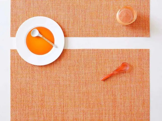 Chilewich | Boucle Rectangle Placemats - Tangerine, featuring a textured crepe weave, shown with a spoon and glass on a plate, ideal for versatile dining settings.