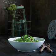 Pillivuyt | Shallow Pasta + Soup Bowl on a table, ideal for salads or entrees, showcasing sleek design in white porcelain.