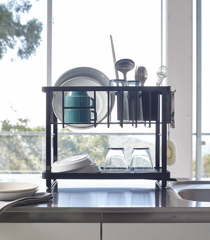 Yamazaki Home | Two-Tier Dish Rack, White, featuring a double-tier design with adjustable draining spout and utensil holder, styled on a kitchen countertop.