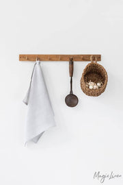 Linen tea towel on a rack with utensils; absorbent, durable, European flax, ideal for kitchen use. Perfect for maintaining a neat kitchen.