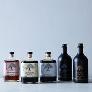 Mikuni Wild Harvest USA - Haku Smoked Shoyu, 375 ml glass bottle, showcased among liquor bottles with distinct craftsmanship and unique flavor from Kyoto.