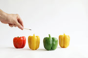 Artifaqt - Bell Pepper Beeswax Candle: Yellow, shaped like a green bell pepper, being lit by a hand, showcasing unique craftsmanship and natural beeswax properties.