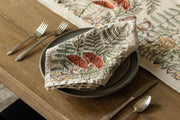Coral & Tusk - Mushrooms and Ferns Bouquet Dinner Napkin, elegantly folded on gray ceramic plates, complemented by a matching botanical table runner.