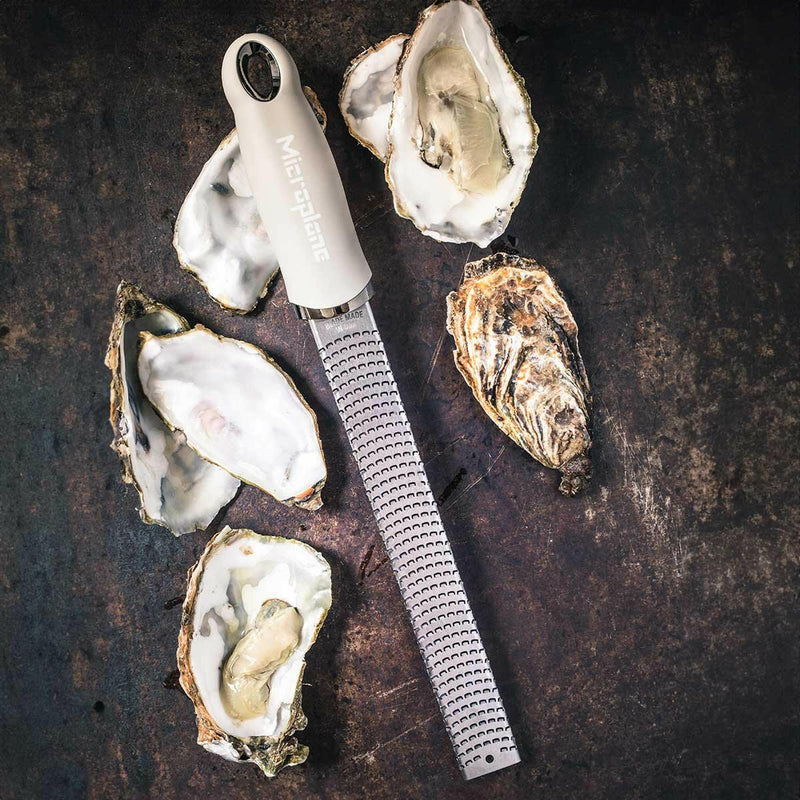 Microplane | Premium Zester, Grater - Classic Blue beside freshly-shucked oysters, showcasing its precision design for zesting and grating, ideal for culinary enthusiasts.
