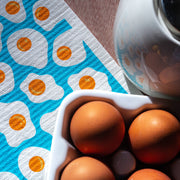 Bespoke Provisions - Eggs Swedish Dishcloth on a table, highlighting its eco-friendly design for cleaning, part of Athens Cooks' curated kitchen tools.