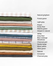 Stack of colorful linen tea towels from MagicLinen, crafted from high-quality European flax, featuring a hanging loop. Ideal for kitchen use.
