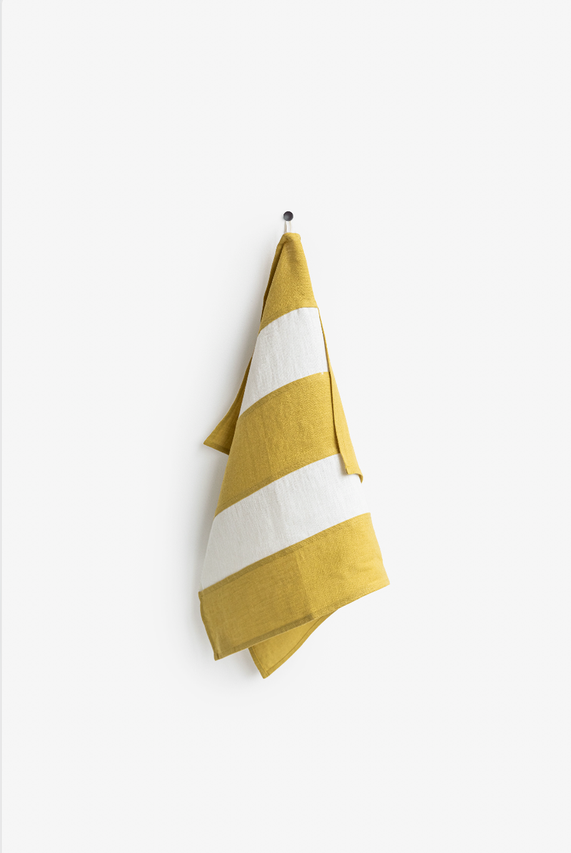 Striped linen tea towel on a hook, showcasing MagicLinen's zero-waste design, perfect for stylish and sustainable kitchen use.