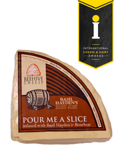 Beehive Cheese Co. LLC | Pour Me A Slice - 4 oz Wedge infused with Basil Hayden Bourbon, showcasing a close-up of the cheese with its artisanal label.