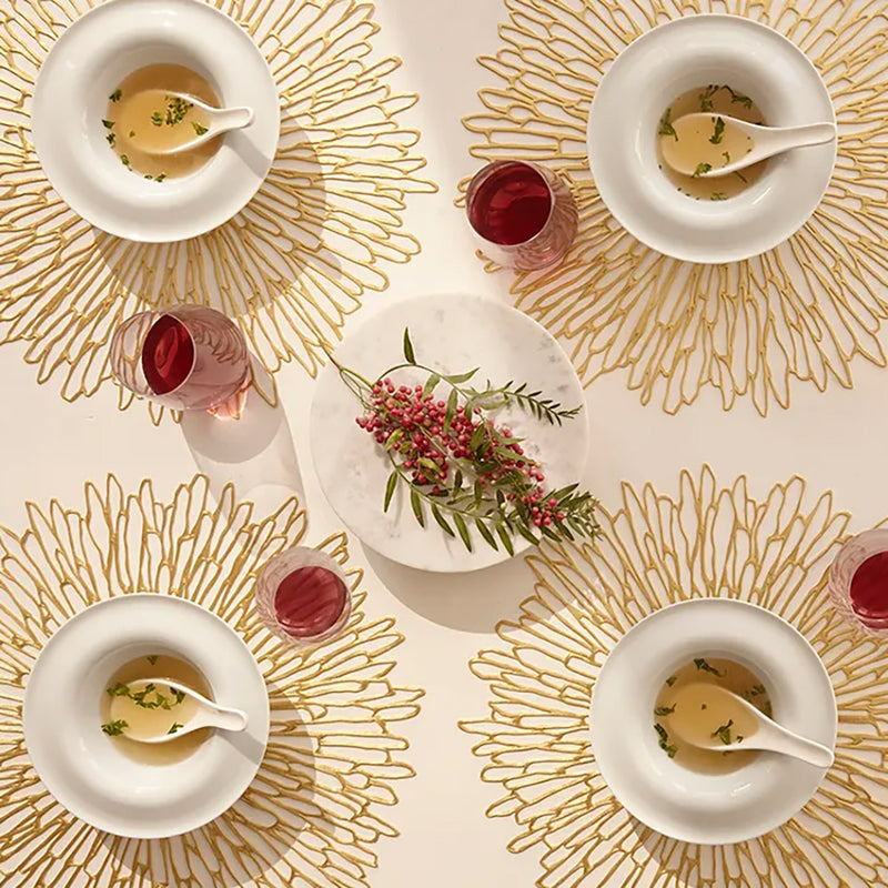 Chilewich | Bloom Placemats - Champagne elegantly displayed on a dining table with bowls of soup and glasses, showcasing its intricate floral openwork design.