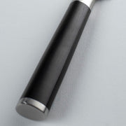 Close-up of the Shun Classic Santoku Ebony knife, 5.5 inches, featuring a black wooden handle with silver metal fittings, ideal for versatile kitchen tasks.