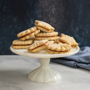 Nordic Ware | Pretty Pleated Cookie Stamps displayed with cookies on a white plate, showcasing intricate star, diamond, and floral imprints.
