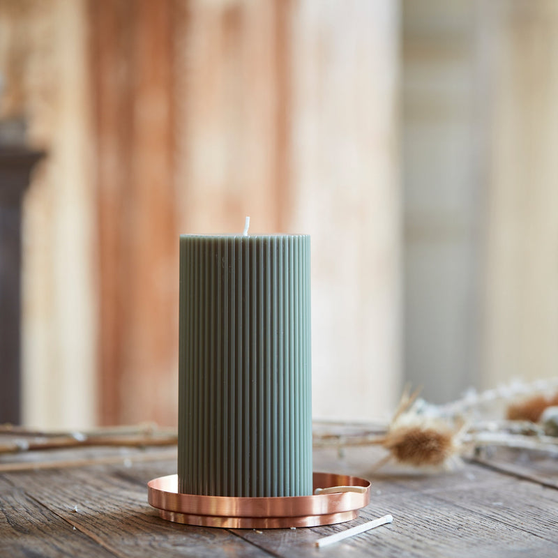The Floral Society | Aura Plate: A copper-toned tray holds a tall, ribbed green pillar candle, ideal for safe burning or as a decorative accent on any tabletop.