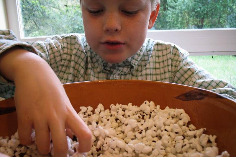 Boy enjoying a bowl of Rancho Gordo | Crimson Popping Corn, showcasing its appeal as a versatile snack, perfect for traditional or air-popped preparation.