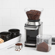 Cuisinart Supreme Grind Automatic Burr Mill with coffee beans and cups, ideal for precise grinding in Athens Cooks' curated kitchenware collection.