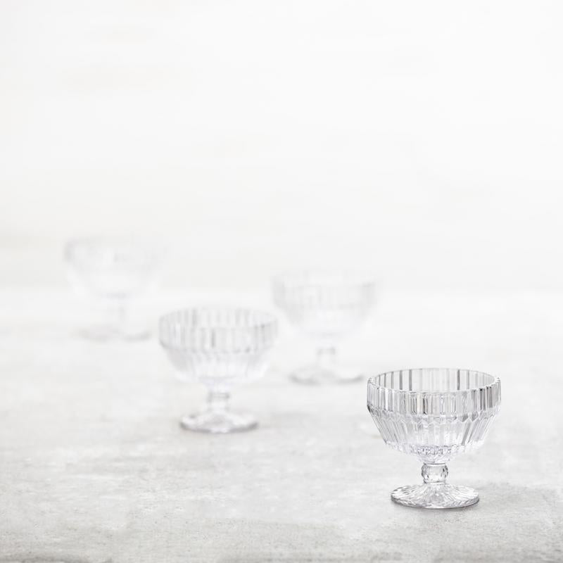 Fortessa | Archie Clear 10oz Footed Dessert Bowl with molded facets, showcasing elegant design and light refraction, ideal for stylish tablescapes. Dishwasher safe, not microwave or oven safe.