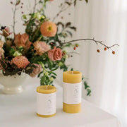 Mo&Co Home - 100% Beeswax Pillar Candles, hand-poured and unscented, set with fresh floral arrangement, showcasing natural elegance for home decor or special occasions.