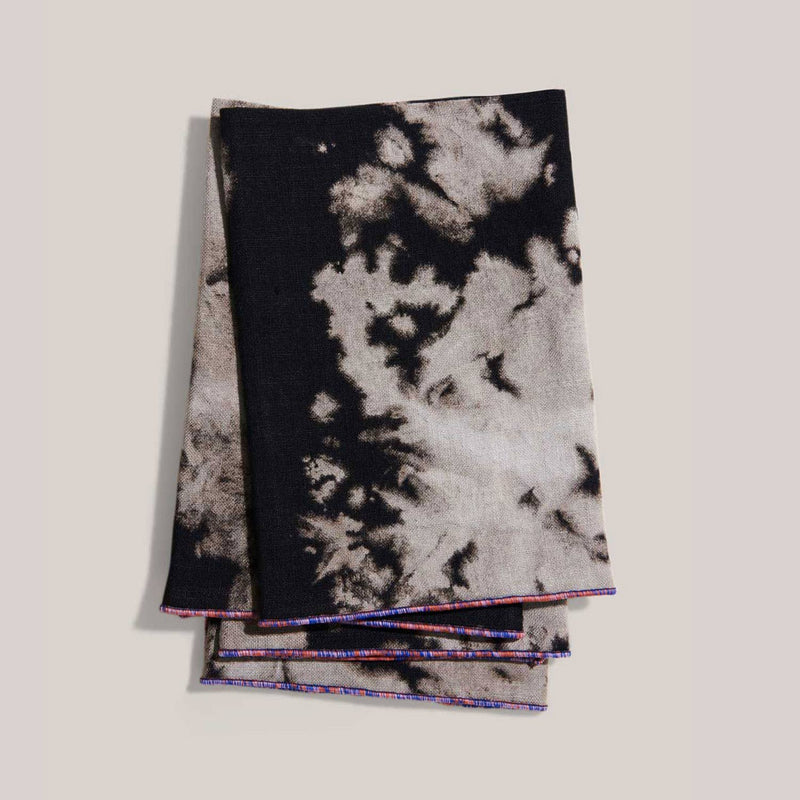 ATELIER SAUCIER - Sundown Linen Napkins: Set of 4 black-and-off-white tie-dyed cloth napkins with multicolored trim, perfect for enhancing elegant table settings.