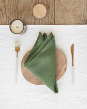 MagicLinen - Set of 2 linen napkins on a wooden plate with a candle, showcasing elegant table decor for versatile dining occasions.