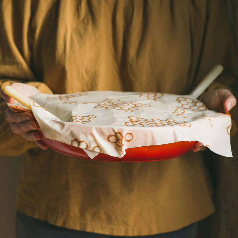 Bee's Wrap - Large 3 Pack Wraps shown covering a pan, highlighting its reusable, sustainable design made from organic cotton and beeswax.