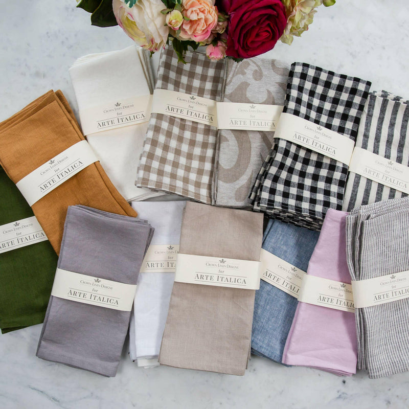 Crown Linen Designs' luxurious washed linen napkin set, folded with a white tag, ideal for enhancing dining experiences at Athens Cooks. Set of four.