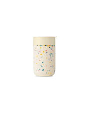 Reusable Ceramic Mug with colorful sprinkles design, featuring a splash-resistant lid and silicone sleeve for grip; ideal for eco-friendly, at-home coffee brewing.